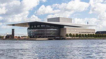 A vertical shot of the Copenhagen Opera House by the water captured in Copenhagen, Denmark