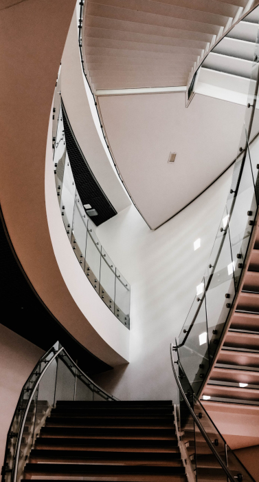 A vertical shot of concrete stairs inside a building with turned-on lights